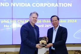 Chủ tịch UBND Thành phố Hồ Chí Minh Phan Văn Mãi tặng quà lưu niệm cho lãnh đạo Tập đoàn NVIDIA. (Ảnh: Tiến Lực/TTXVN)
