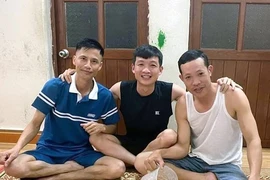 Anh Trần Văn Ninh, người bị đuối nước (ngồi giữa) hai anh Vinh (bên phải) và anh Cường (bên trái). (Ảnh: TTXVN phát)