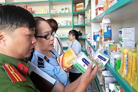 Đoàn giám sát Hội đồng Nhân dân Thành phố Hồ Chí Minh kiểm tra tại một cơ sở kinh doanh thuốc trên địa bàn quận Tân Phú. (Ảnh: Đinh Hằng/TTXVN)
