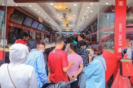 Nhiều người xếp hàng để chờ đến lượt mua, bán vàng tại cửa hàng Bảo Tín Minh Châu. (Ảnh: Hoàng Hiếu/TTXVN)