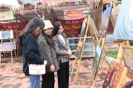 Du khách tham quan khu trưng bày ảnh về văn hóa Bắc Ninh tại Trung tâm Bảo tồn tranh dân gian Đông Hồ, thị xã Thuận Thành. (Ảnh: Thanh Thương/TTXVN)