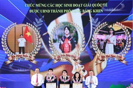 Chủ tịch UBND thành phố Hà Nội tặng bằng khen cho các học sinh xuất sắc, có nhiều thành tích. (Ảnh: Thanh Tùng/TTXVN)