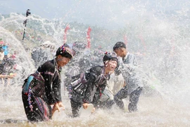Người dân và du khách cùng hòa vào suối Nậm Mu tham gia Lễ hội té nước. (Ảnh: Nguyễn Oanh/TTXVN)