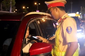 Cảnh sát giao thông kiểm tra nồng độ cồn một trường hợp tài xế ôtô. (Ảnh: Nguyễn Thanh/TTXVN)