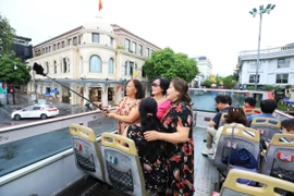 Du khách hào hứng khi được tham quan Hà Nội bằng xe buýt 2 tầng. (Ảnh: Tuấn Anh/TTXVN)