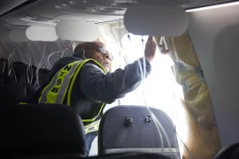 Điều tra viên kiểm tra phần cửa sổ bị bung ra của máy bay Boeing 737 MAX 9 thuộc hãng hàng không Alaska Airlines. (Ảnh: AFP/TTXVN)