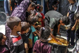 Các em nhỏ chờ được phát thức ăn cứu trợ tại trại tị nạn Jabalia, Dải Gaza, ngày 8/6/2024. (Ảnh: THX/TTXVN)