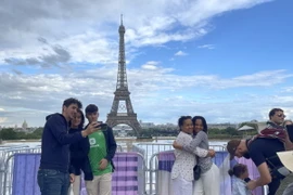 Người dân và khách du lịch chụp ảnh kỷ niệm từ xa do quảng trường Trocadero và cầu Iena dẫn sang tháp Eiffel đã được trưng dụng cho các hoạt động của Thế vận hội Olympic. (Ảnh: Thu Hà/TTXVN)
