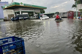 Ngập úng sâu ở cây xăng trên đường Nguyễn Văn Linh, Quận 8. (Ảnh: Thanh Vũ/TTXVN)