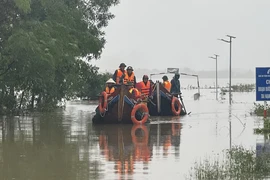 Các lực lượng chức năng di chuyển bằng thuyền hỗ trợ người dân vùng ngập lụt. (Ảnh: Thanh Thủy/TTXVN)