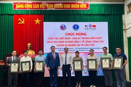 Đại sứ Hoa Kỳ tại Việt Nam trao tặng Giấy khen cho các đơn vị có nhiều đóng góp trong triển khai mô hình đáp ứng y tế công cộng với chùm ca nhiễm. (Ảnh: Ánh Tuyết/TTXVN)