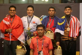 Vận động viên Nguyễn Văn Trí (thứ hai từ trái sang) nhận huy chương vàng. (Ảnh: Quốc Khánh/TTXVN)