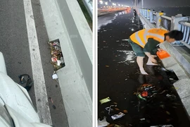Công nhân kiểm tra, dọn vệ sinh rác trên mặt Cầu Vĩnh Tuy 2. (Ảnh: Ban Quản lý dự án cung cấp)