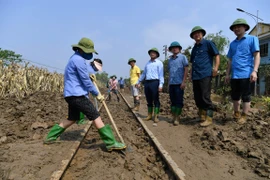 Nhân viên đường sắt dọn dẹp bùn trong khu vực ray tàu hỏa để thông tuyến, chạy tàu trở lại. (Ảnh: PV/Vietnam+)