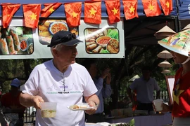 Một thực khách người Nam Phi hào hứng với món phở và nem rán tại sự kiện Ngày Phở Việt Nam tại Nam Phi 2023. (Ảnh: Hồng Minh/TTXVN) 