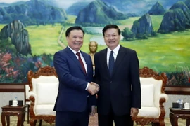 Tổng Bí thư, Chủ tịch nước Lào Thongloun Sisoulith chào đón đồng chí Đinh Tiến Dũng cùng Đoàn đến chào xã giao. (Ảnh: Phạm Kiên/TTXVN)