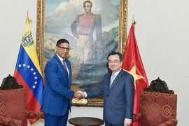 Bộ trưởng Bộ Xây dựng Nguyễn Thanh Nghị (phải) và Bộ trưởng Dân cư và Nhà ở Venezuela Ildemaro Villarroel. (Ảnh: TTXVN phát)
