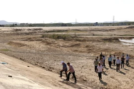 Đoàn kiểm tra hạn hán tại hồ Tà Mon, huyện Hàm Thuận Nam (Bình Thuận), hiện hồ này đã cạn trơ đáy và dừng hoạt động từ đầu tháng 3/2024. (Ảnh: Nguyễn Thanh/TTXVN)