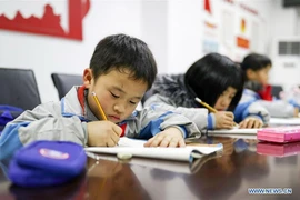 Học sinh tiểu học làm bài tập về nhà tại một trung tâm chăm sóc sau giờ học ở quận tự trị Yuping Dong, tỉnh Quý Châu, Tây Nam Trung Quốc. (Ảnh: Tân Hoa xã)