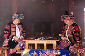 Phụ nữ Lô Lô với bàn tay khéo léo thêu hoa văn trên trang phục truyền thống. (Ảnh: Trần Việt/TTXVN)