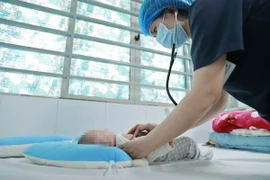 Bác sỹ khám cho một bệnh nhi hơn 2 tháng tuổi mắc ho gà đang điều trị tại Trung tâm bệnh Nhiệt đới-Bệnh viện Nhi Trung ương. (Ảnh: Minh Quyết/TTXVN)