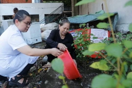 Nhân viên y tế xã Thượng Mỗ, huyện Đan Phượng, Hà Nội, hướng dẫn người dân xử lý nước thừa, nước đọng tại các vật dụng, đồ dùng sinh hoạt trong gia đình. (Ảnh: Minh Quyết/TTXVN)