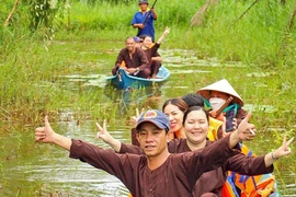 Du khách thích thú với hình thức đi xuyên rừng bằng xuồng ba lá tại điểm du lịch sinh thái ở vùng rừng U Minh hạ. (Ảnh: Huỳnh Anh/TTXVN)
