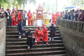 Các cụ cao niên lấy nước tại Giếng Ngọc để rước về Đền Vua Bà trong lễ hội làng Diềm. (Ảnh: Thanh Thương/TTXVN)