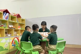 Cô Nguyễn Thị Mai, Giám đốc Trung tâm Hỗ trợ giáo dục hòa nhập trẻ tự kỷ Hoàng Đức (thành phố Biên Hòa, Đồng Nai) cùng chơi với trẻ tự kỷ trong tiết can thiệp cá nhân. (Ảnh: Lê Xuân/TTXVN)