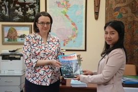 Phóng viên thường trú TTXVN trao tặng ấn phẩm Báo Ảnh Việt Nam cho Giám đốc Trung tâm ASEAN tại Đại học quan hệ quốc tế MGIMO thuộc Bộ Ngoại giao Nga Ekaterina Koldunova. (Ảnh: Quang Vinh/TTXVN)