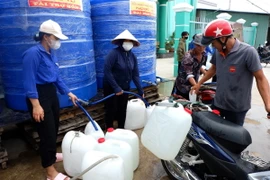 Thanh niên và dân quân là lực lượng túc trực thường xuyên hỗ trợ cấp nước cho người dân vùng hạ huyện Cần Giuộc, tỉnh Long An. (Ảnh: Đức Hạnh/TTXVN)