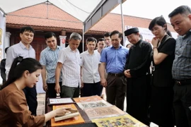 Các đại biểu tham quan một gian hàng tại Không gian trưng bày tái hiện Chợ tranh Đông Hồ. (Ảnh: Đỗ Huyền/ TTXVN)
