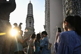 Khách du lịch tham quan một ngôi chùa ở Bangkok, Thái Lan. (Ảnh: AFP/TTXVN)