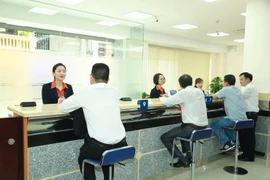 Hoạt động giao dịch tại Sacombank. (Ảnh: PV/Vietnam+)