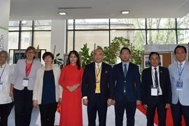 Phó Chủ nhiệm Ủy ban Nhà nước về người Việt Nam ở nước ngoài Nguyễn Mạnh Đông (thứ tư, phải) và Đại sứ Việt Nam tại Ba Lan Hà Hoàng Hải (thứ ba, phải) chụp ảnh cùng các đại biểu dự hội thảo. (Ảnh: TTXVN phát)