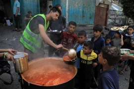 Trẻ em Palestine nhận thức ăn cứu trợ tại thành phố Rafah, Dải Gaza ngày 28/4/2024. (Ảnh: THX/TTXVN)