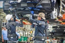 Công nhân làm việc trên dây chuyền sản xuất xe ôtô của Hãng BMW (Đức). (Ảnh: DW/TTXVN)