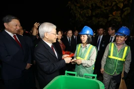 Tổng Bí thư, Chủ tịch nước Nguyễn Phú Trọng chúc Tết, tặng quà công nhân môi trường đang làm việc trong đêm giao thừa Tết Nguyên đán Kỷ Hợi 2019. (Ảnh: Trí Dũng/TTXVN)