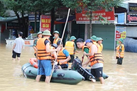 Các lực lượng chức năng sử dụng mọi phương tiện để vận chuyển nhu yếu phẩm đến với người dân bị ngập sâu tại phường Quang Vinh, thành phố Thái Nguyên. (Ảnh: Hoàng Nguyên/TTXVN)