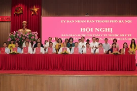 Lãnh đạo thành phố Hà Nội đã chứng kiến lễ ký biên bản bàn giao giữa Sở Y tế Hà Nội và 30 quận, huyện, thị xã. (Ảnh: Nguyễn Cúc/TTXVN)