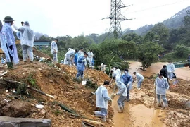 Cán bộ, chiến sỹ Công an tỉnh Hà Giang và các lực lượng chức năng nỗ lực tìm kiếm nạn nhân mất tích trong vụ sạt lở nghiêm trọng. (Ảnh: TTXVN phát)