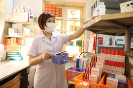 Nhân viên y tế làm công tác cấp phát thuốc. (Ảnh: PV/Vietnam+)