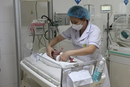Bác sĩ Khoa Hồi sức sơ sinh chăm sóc bé sinh non. (Ảnh: Bích Huệ/TTXVN) 