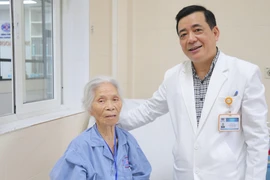 Phó giáo sư Phạm Văn Bình và bệnh nhân sau ca phẫu thuật. (Ảnh: PV/Vietnam+)