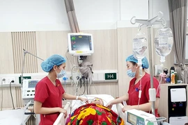 Điều dưỡng Đặng Thị Hạ chăm sóc cho một bệnh nhân tại Bệnh viện Bạch Mai. (Ảnh: M.T/Vietnam+)