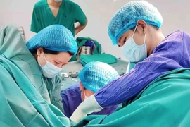 Bác sĩ điều trị cho bệnh nhân bị trĩ tại Bệnh viện Tuệ Tĩnh. (Ảnh: PV/Vietnam+)