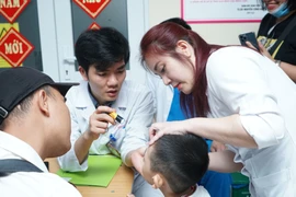 Bác sĩ Bệnh viện E thăm khám cho trẻ mắc dị tật khe hở môi, vòm miệng. (Ảnh: PV/Vietnam+)