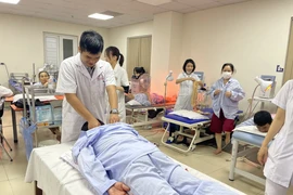 Nhân viên y tế làm công tác phục hồi chức năng cho người bệnh tại Bệnh viện Tuệ Tĩnh. (Ảnh: PV/Vietnam+)
