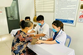 Các bác sỹ khám bệnh cho người dân trong các chương trình tri ân dịp tháng Bảy. (Ảnh: PV/Vietnam+)