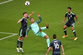 Cristiano Ronaldo (giữa) tranh bóng bổng với các cầu thủ Xứ Wales. (Nguồn: EPA/TTXVN)